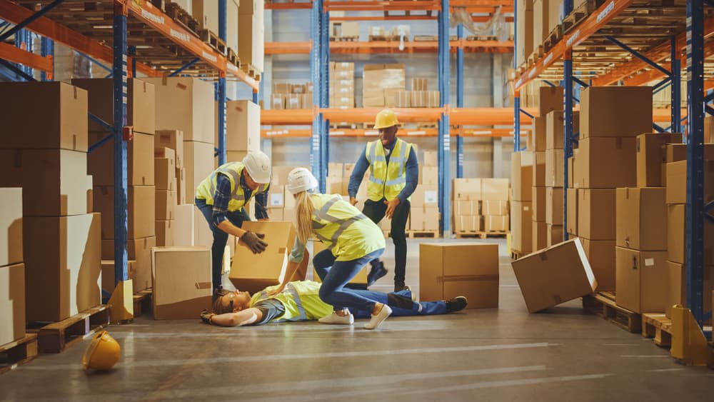 worker injured by boxes in warehouse; employees helping to aid his work injury
