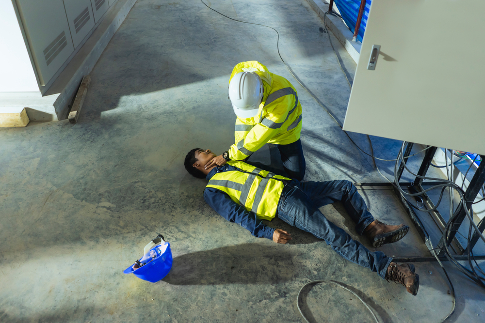 Coworker attempting to resuscitate another coworker after an electrical shock on the ground