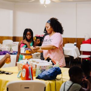 a Jebaily Law Firm team member talks to two young children at a community event