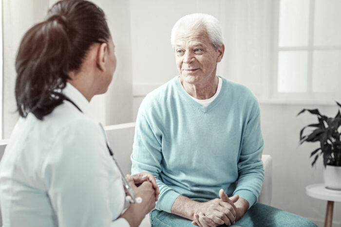 senior citizen sitting in a consultation talking to a doctor