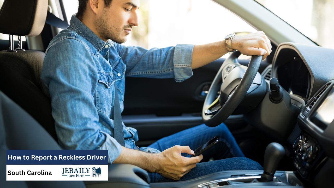 The picture shows a man sitting in a car, looking at his phone with a serious expression, while also holding the steering wheel.