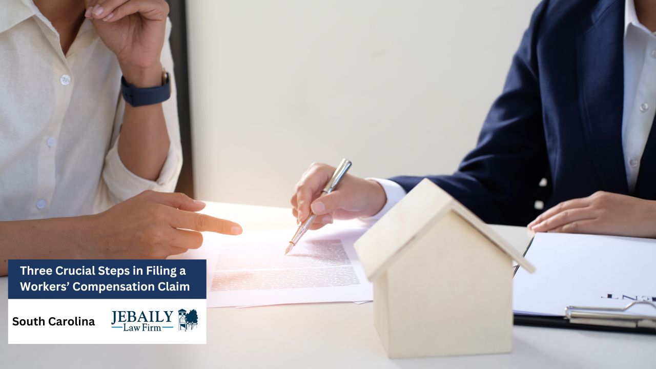 Two professionals are seated at a table, reviewing and signing documents related to a workers' compensation claim, with a small house model present suggesting a possible property dispute.