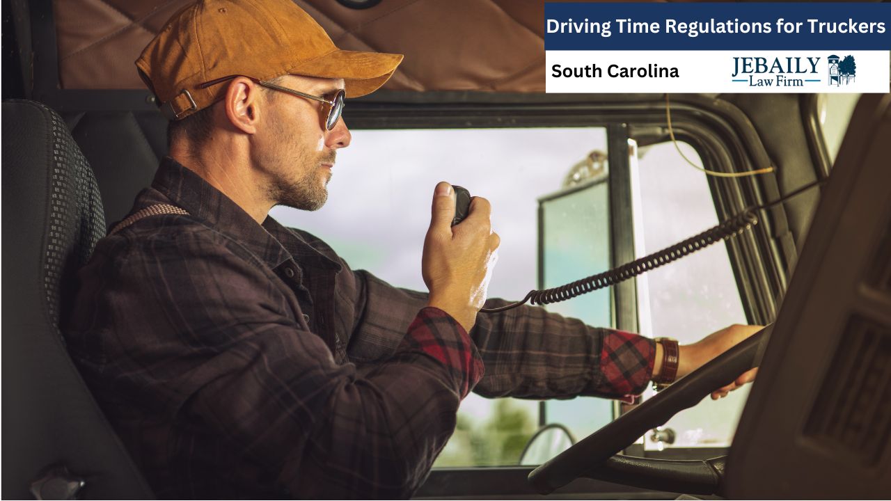 The image shows a close-up of a male trucker sitting in the driver's seat of his semi-truck. He is wearing a brown baseball cap, sunglasses, and a plaid shirt over a dark long-sleeved shirt.