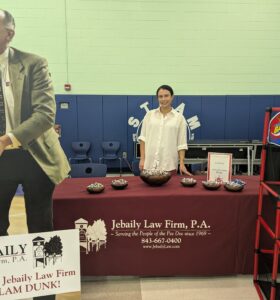 Attorney Kayla Jebaily Adams stands behind Jebaily Law Firm's table at Carver Elementary's Career Day event