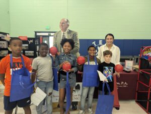 Kayla Jebaily Adams poses for a picture with smiling students at Carver Elementary's Career Day