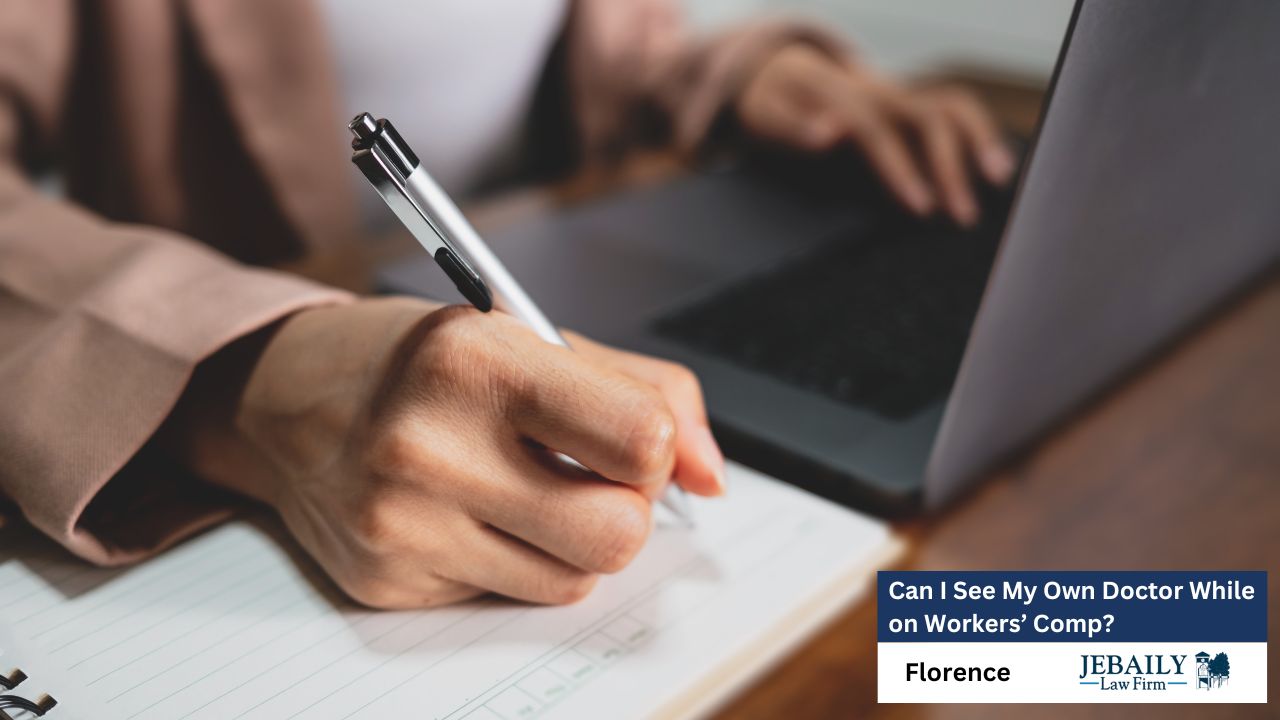 A person is taking notes in a notebook while using a laptop.