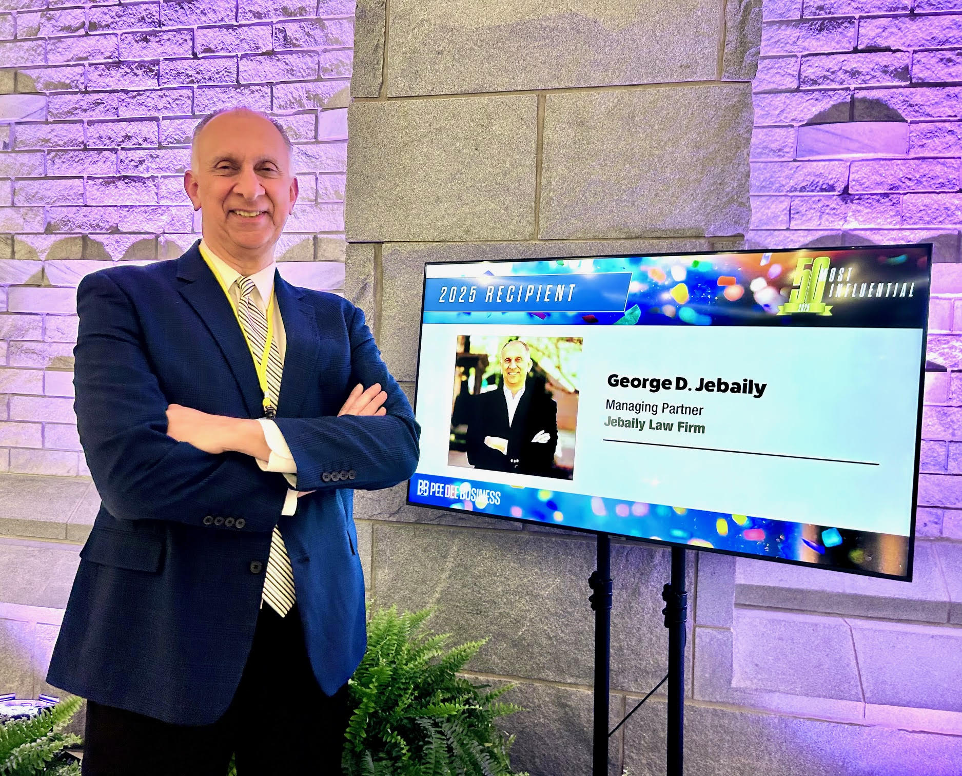 George Jebaily stands next to a sign recognizing him for making top 50 Pee Dee people