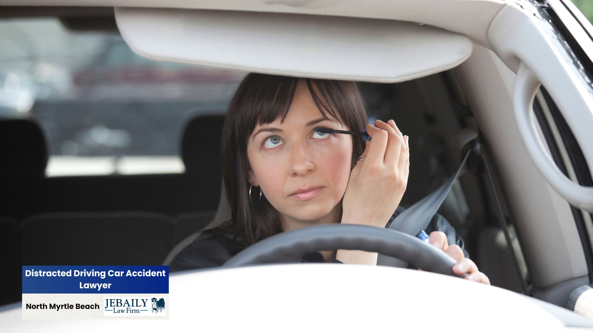 A woman is applying mascara while driving, highlighting the dangers of distracted driving.