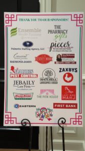 A sign on a stand listing the sponsors of the Tiles of Hope event.